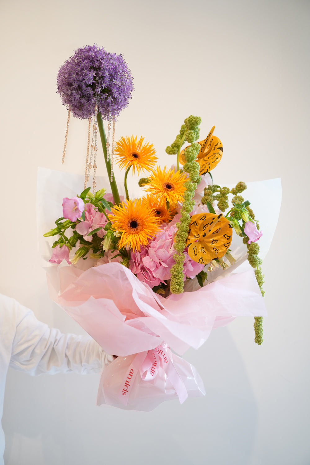 Bouquet of flowers with pink and orange colors And some art touch on it made by amicis flower boutique in uae