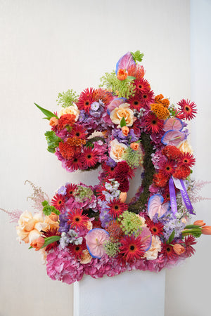 Colorful floral wreath in letter D shape with a white background