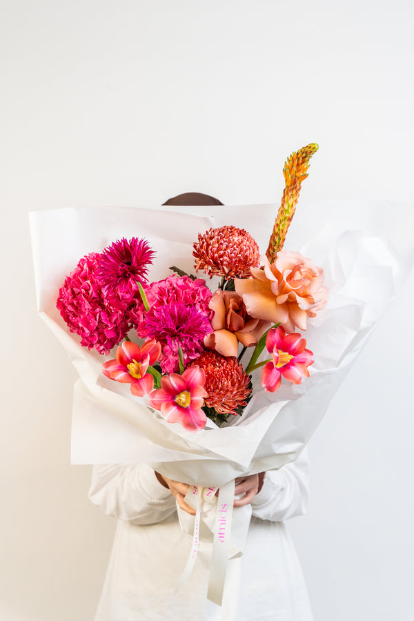 A lush blend of peach, pink, and fuchsia blooms, Rosé Rhapsody is a hand-tied bouquet that dances with feminine energy and modern romance. Bursting with color and charm, it's a captivating arrangement made to celebrate beauty in all its bold and delicate forms. flower by amicis flower boutique in uae