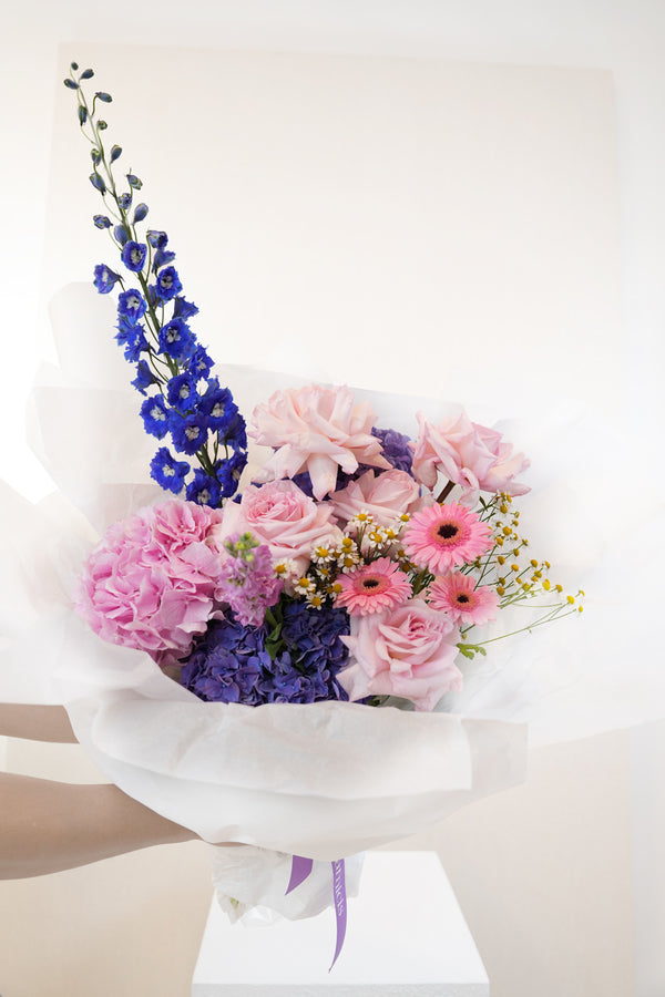Bouquet of pink, purple, and blue flowers on a white background