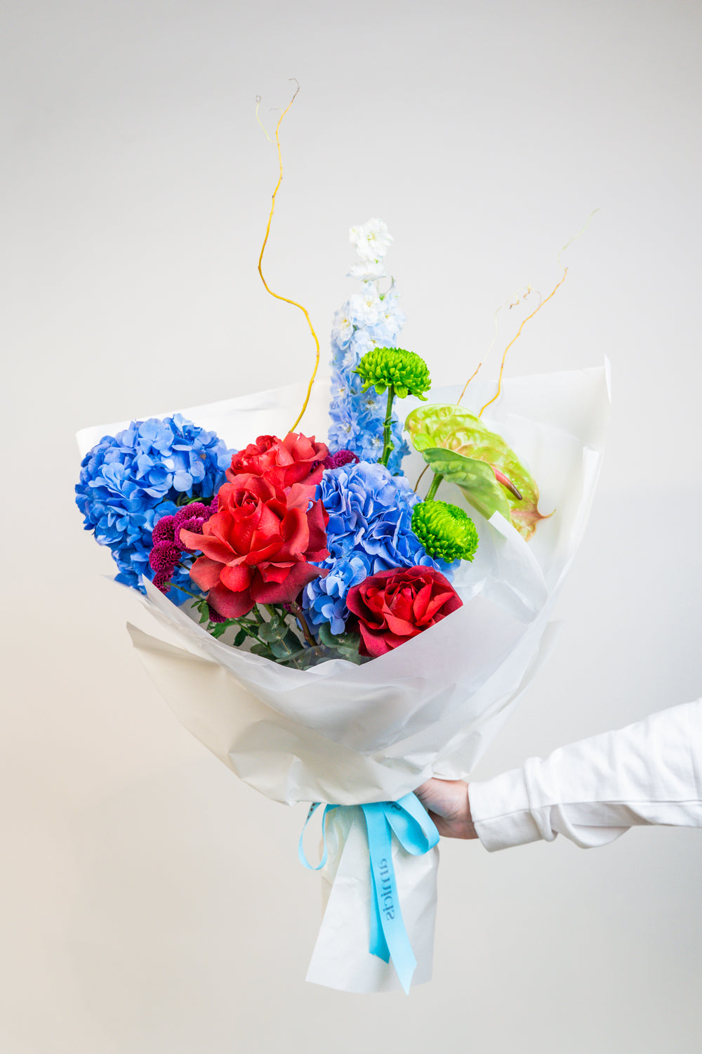 A vibrant celebration of color, Prism Bloom brings together the bold beauty of primary hues—radiant reds, sunshine yellows, and brilliant blues—in a joyful hand-tied bouquet. Bursting with energy and playful charm, it’s a spirited expression of creativity and confidence. by amicis uae