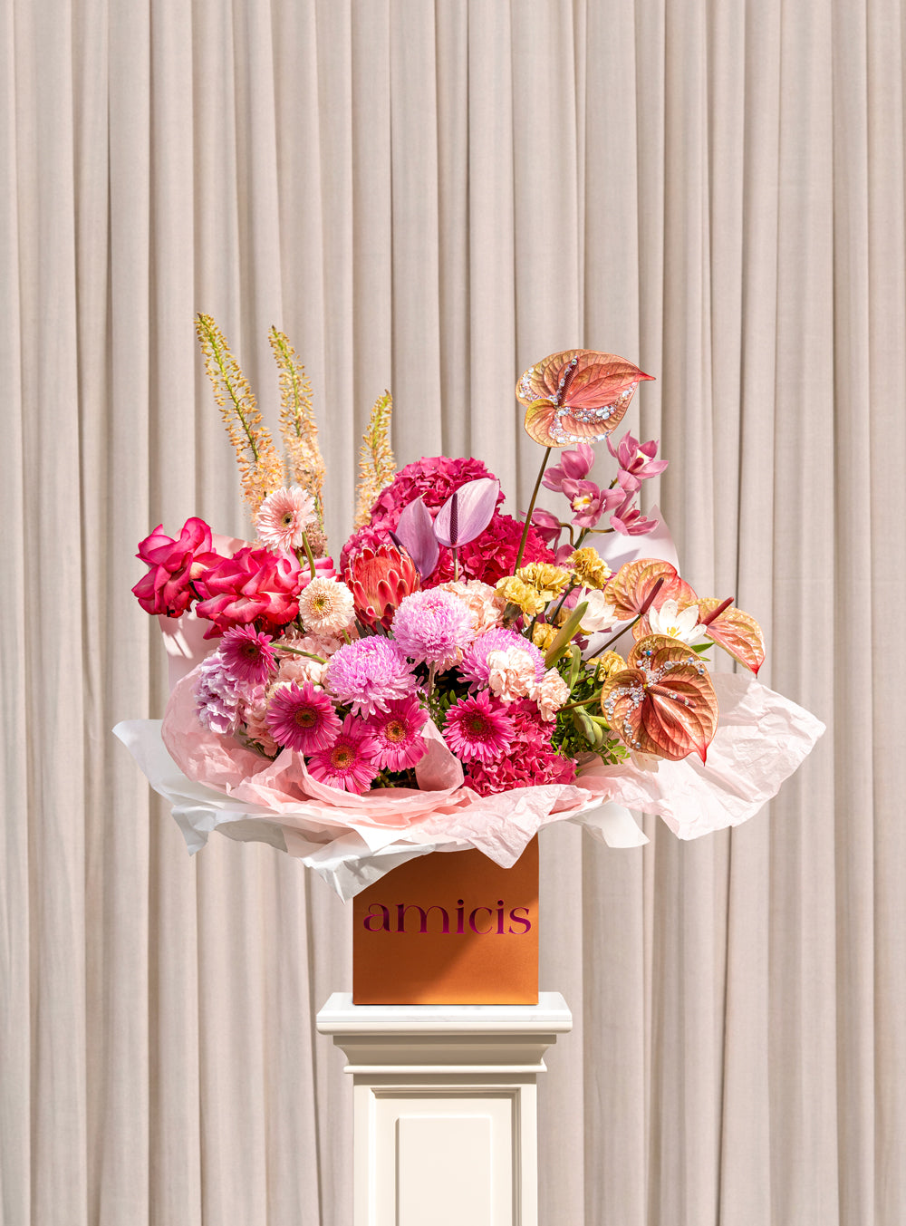 Carmine fuchsia and pink arrangement with hydrangea, gerbera, protea, cymbidium orchid and copper anthurium in a copper Amicis box