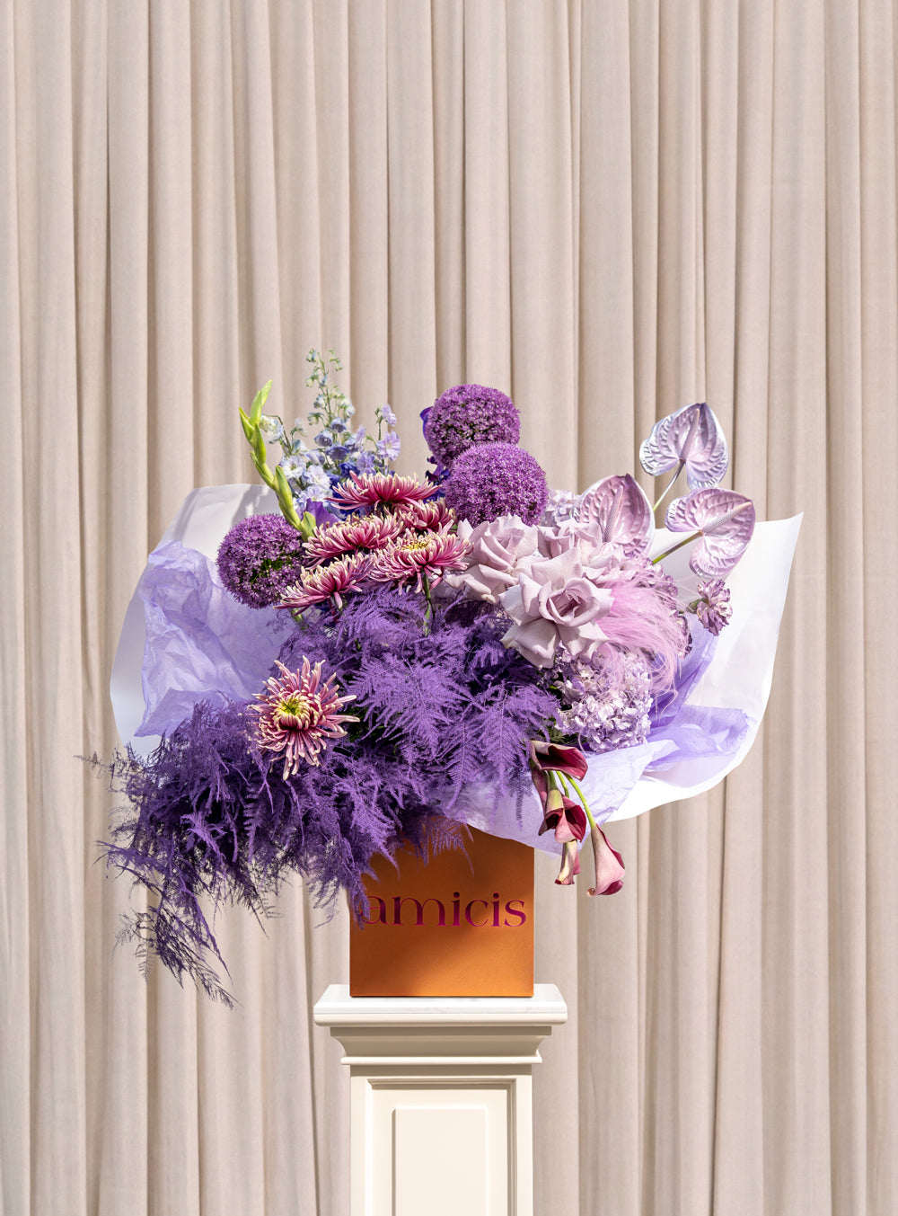 Ardour lavender and plum arrangement with purple chrysanthemums, allium spheres, lavender roses and plum calla lilies in a copper Amicis box