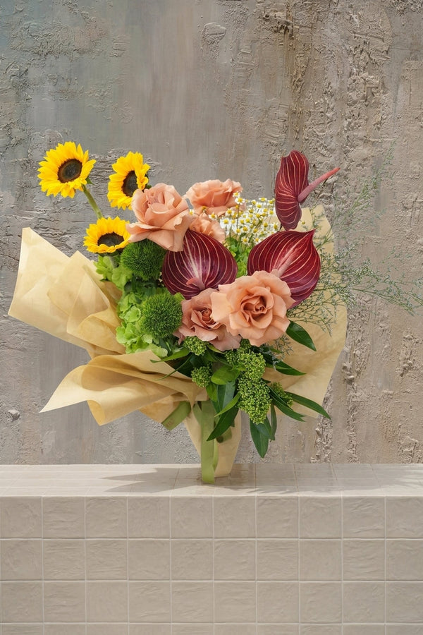 Automated - vibrant yellow sunflowers, peach roses, deep red anthurium, and green hydrangeas in a kraft paper wrapped bouquet by Amicis