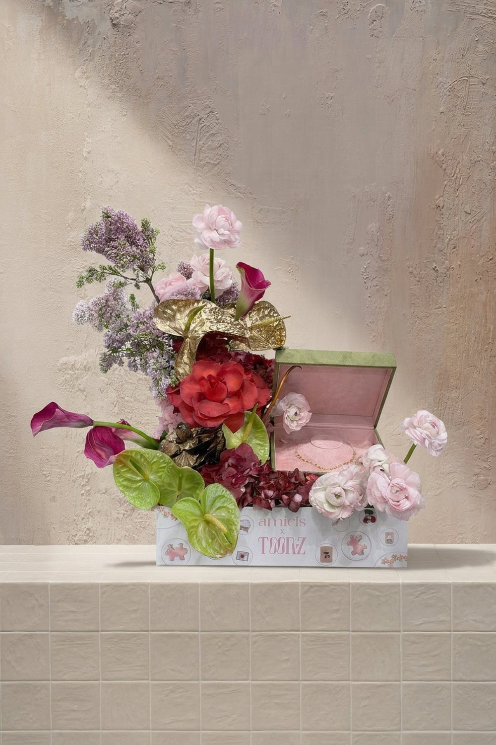 Bespoke Toonz - red roses, blush ranunculus, lavender delphinium, magenta calla lilies, and green anthurium in a branded gift box by Amicis