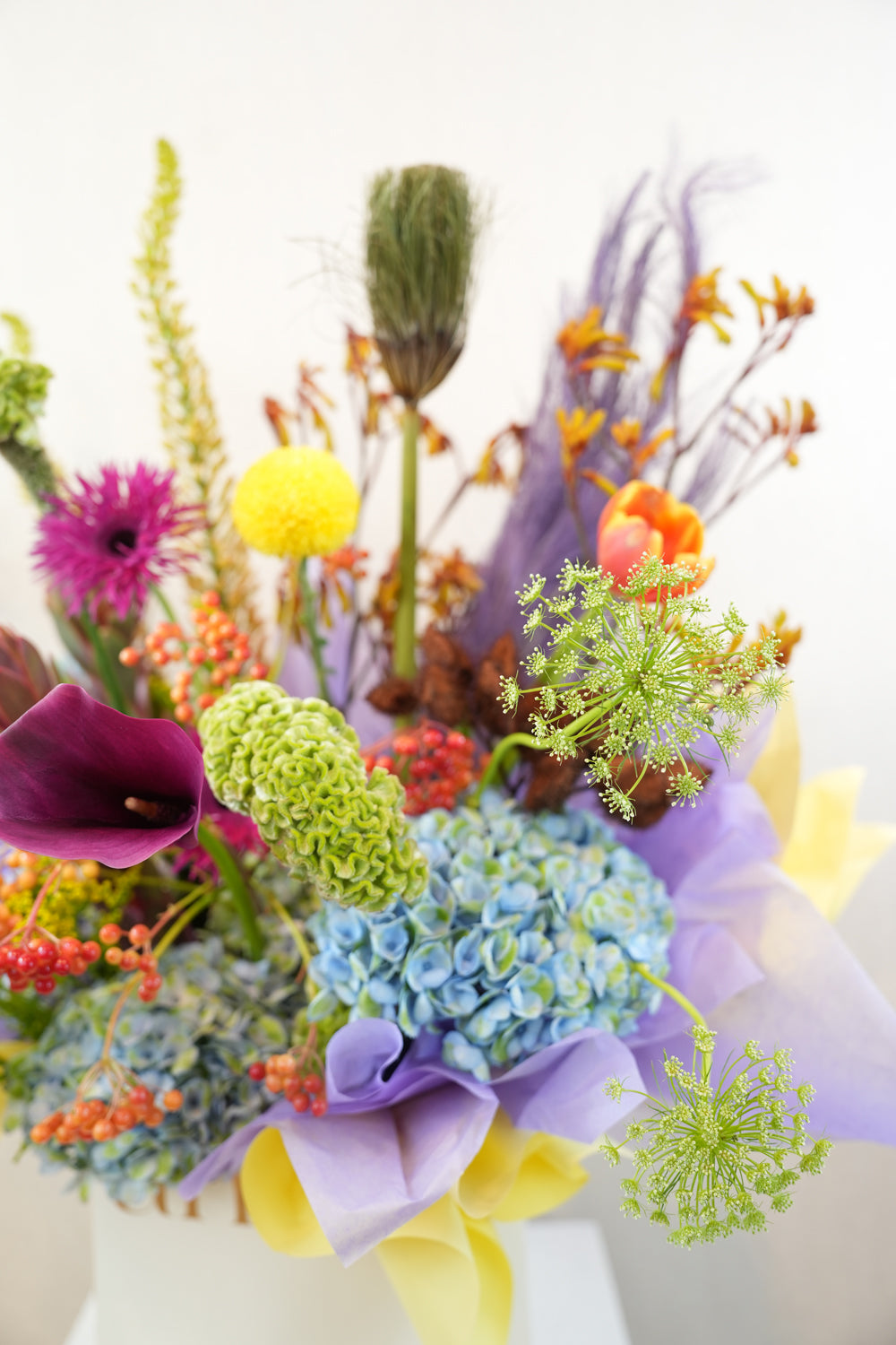 ith a striking medley of indigo hydrangeas, golden blooms, fiery orange accents, and sculptural textures, this bouquet is a symphony of contrasts by amicis flower shop in dubai same day delivery