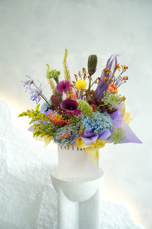 ith a striking medley of indigo hydrangeas, golden blooms, fiery orange accents, and sculptural textures, this bouquet is a symphony of contrasts by amicis flower shop in dubai same day delivery