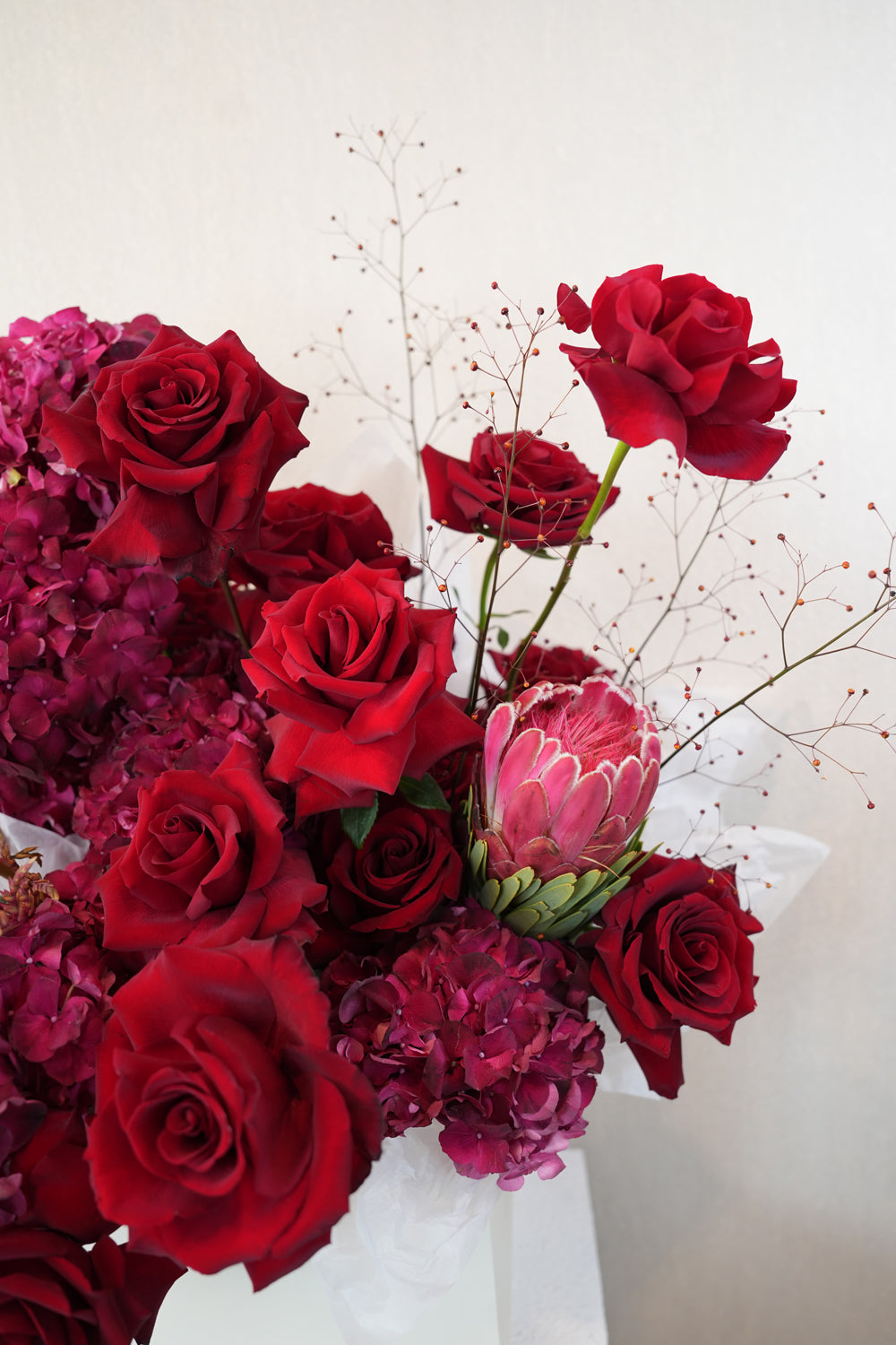 bouquet of red roses and red hydrangeas made by amicis flower shop