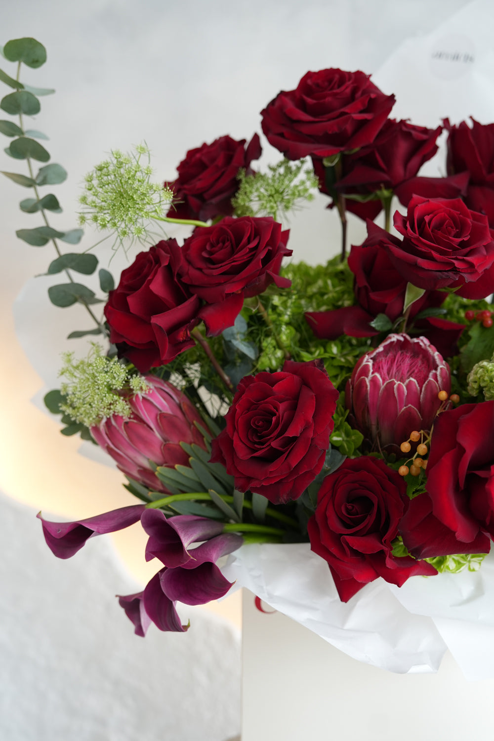 Bouquet of red roses and greenery in amicis white box to be deliver inside uae