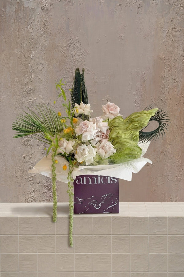 Cinnamon Leaf - blush pink & cream roses with yellow accents, varied green foliage, and trailing amaranthus in a branded box by Amicis