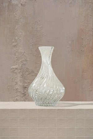 Crystal Oracle - white roses, cream hydrangeas, and delicate orchids in a clear twisted glass vase by Amicis.