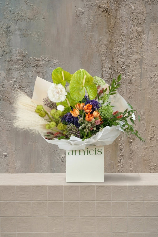 Floral Moderne - lime green anthurium, orange tulips, purple hydrangeas, white alliums, and pampas grass in a cream gift box by Amicis