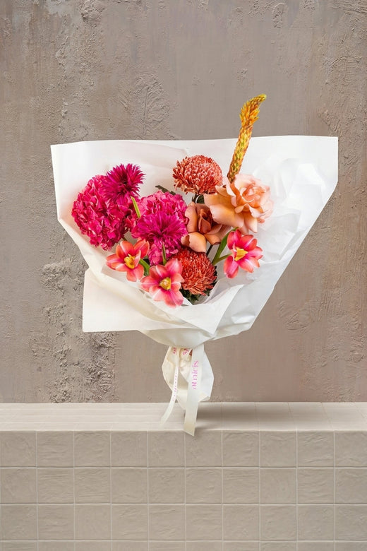 Rosé Rhapsody - deep pink dahlias, peach roses, orange tulips, pincushion protea, and yellow