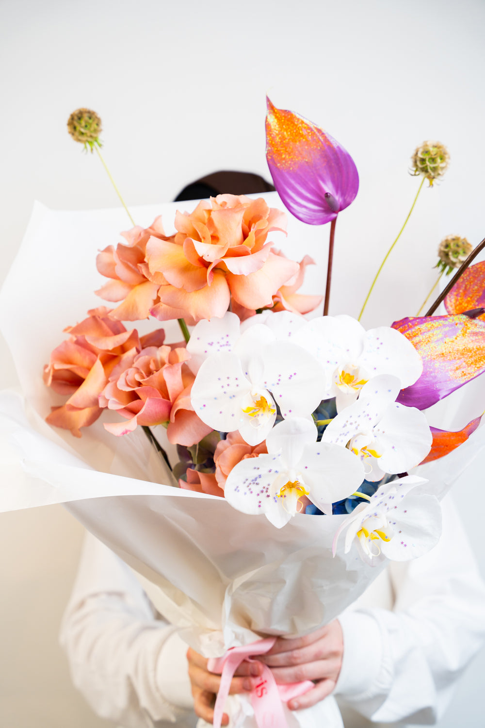 A dreamy fusion of peach, purple, and vibrant orange hues, Orchid Mirage features exotic orchids nestled among lush blooms. This hand-tied bouquet is a radiant blend of elegance and boldness—crafted to enchant, inspire, and leave a lasting impression flower bouquet made by amicis
