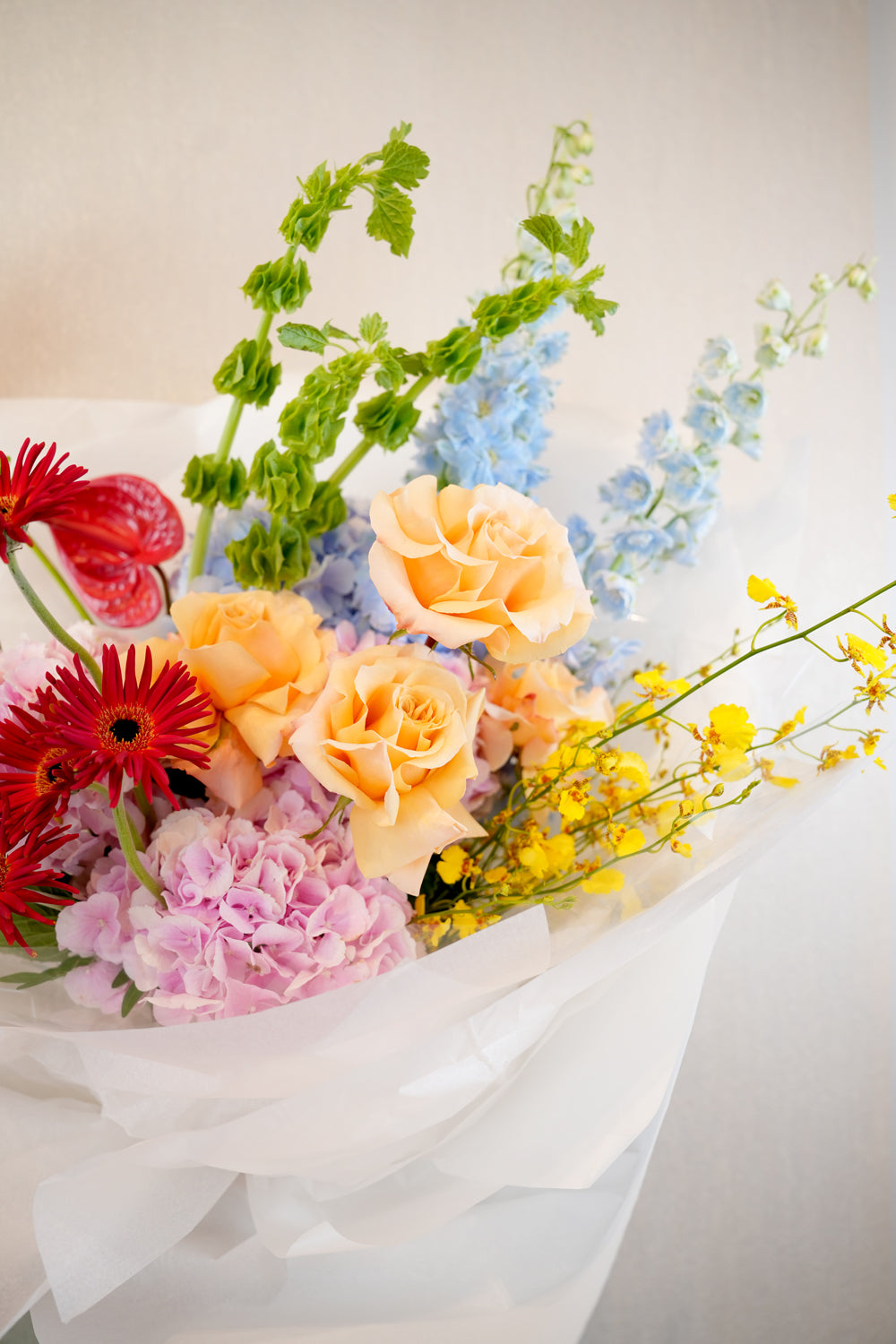 Bouquet of colorful flowers being held by a person against a white background