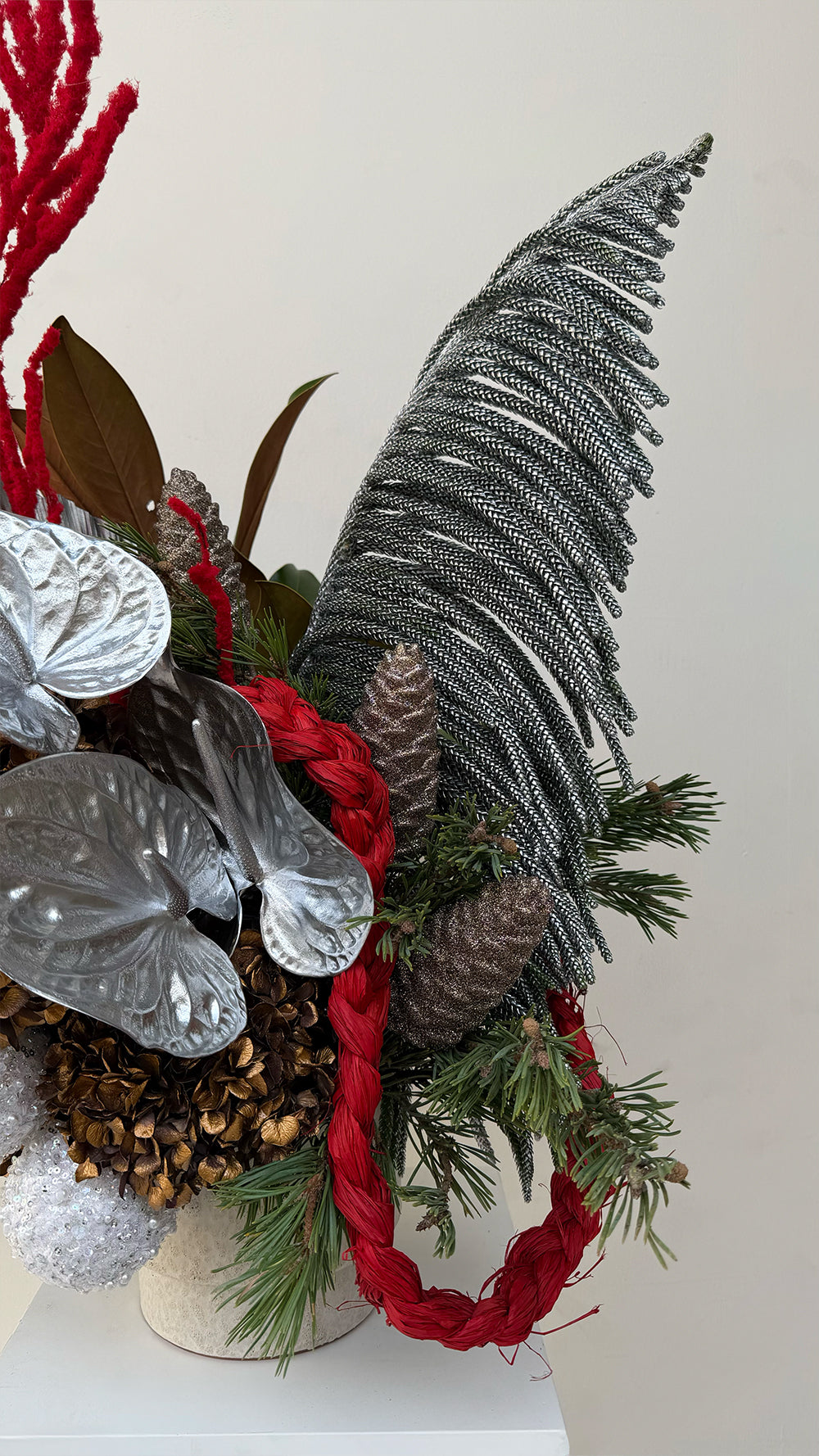Sparkle Holidays 14 - vibrant red amaranthus, silver anthurium, brown dried hydrangeas, and green pine in a cream ceramic pot by Amicis