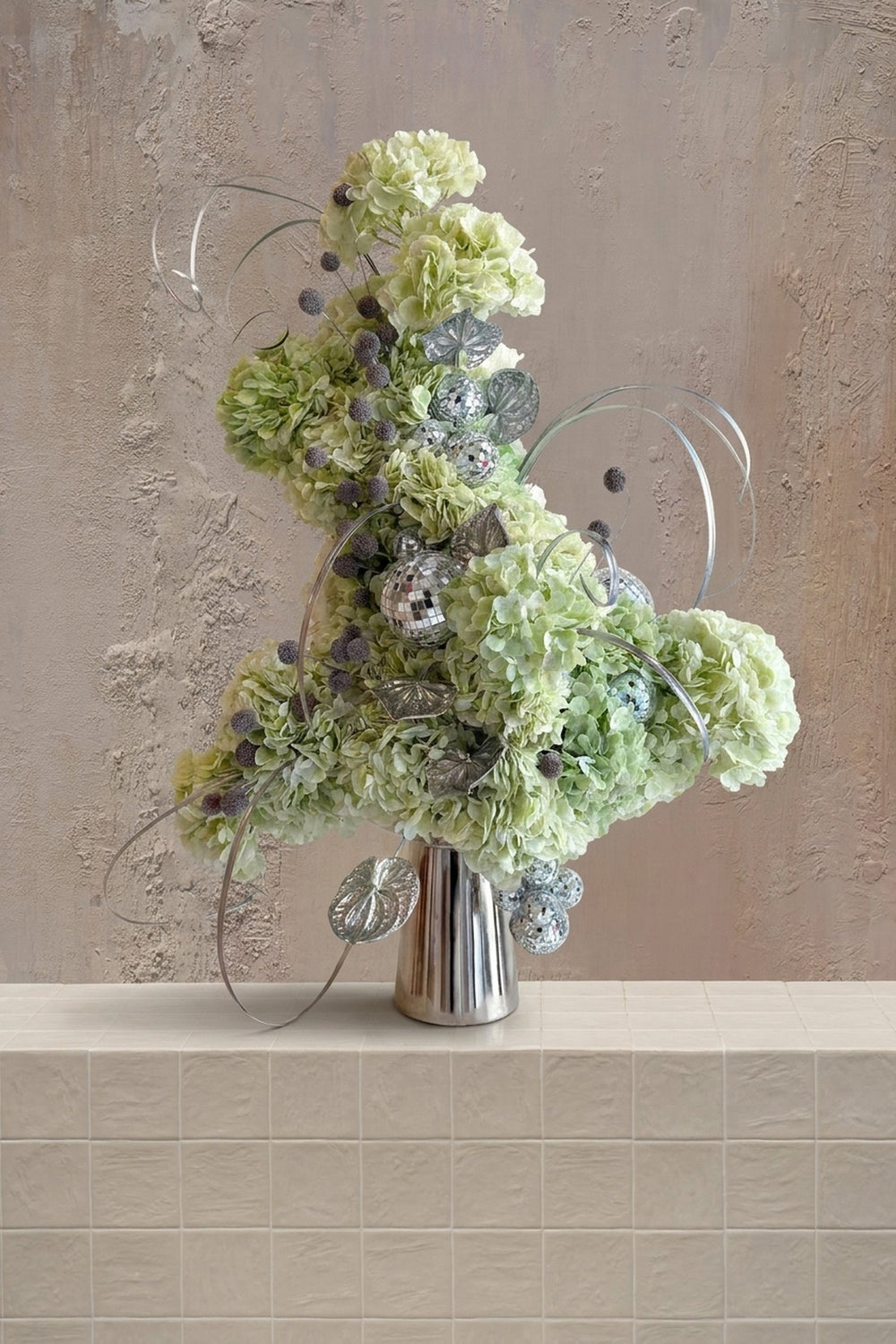 Hydrengea Sparks - lime green hydrangeas with silver disco balls and decorative accents in a silver ribbed vase by Amicis