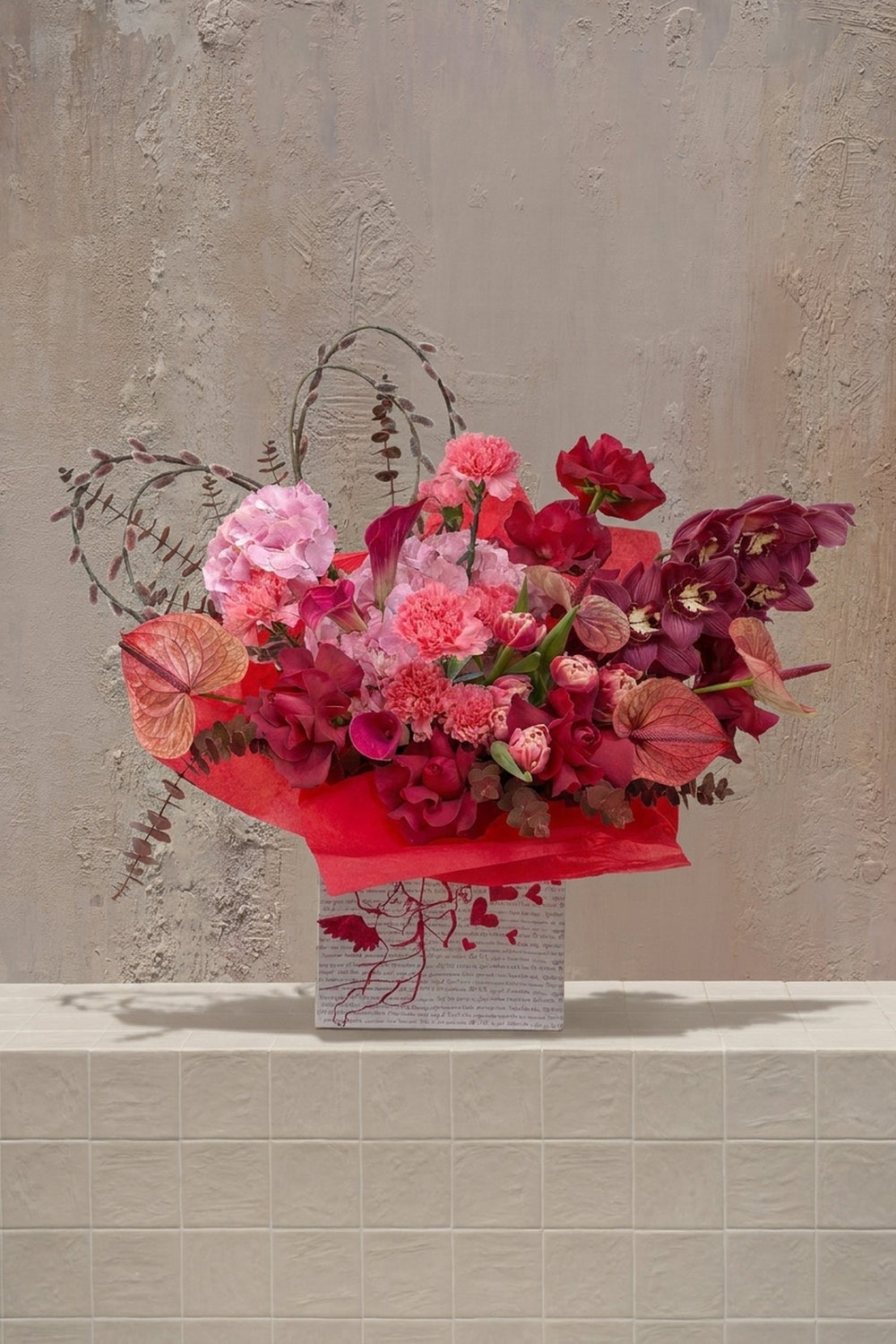 Love You Bunches - pink hydrangeas, red roses, carnations, burgundy orchids, anthurium, and tulips in a red-wrapped gift box by Amicis