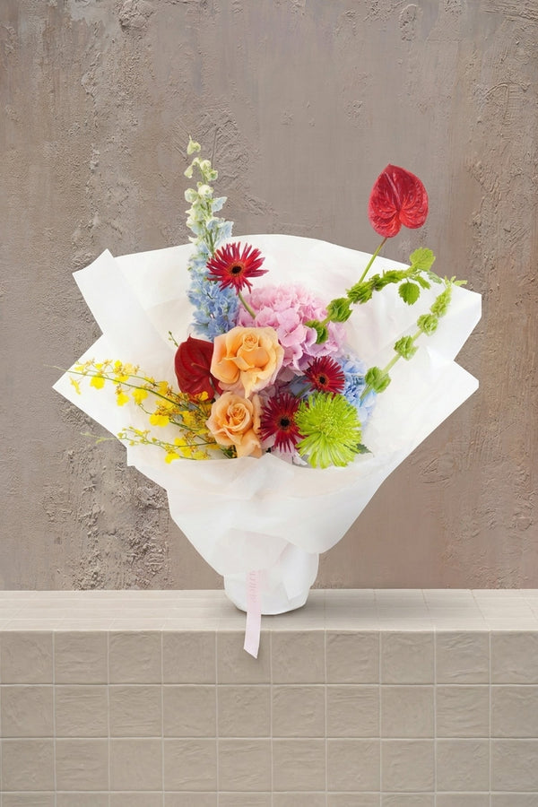 Bouquet of colorful flowers held by a person against a white background