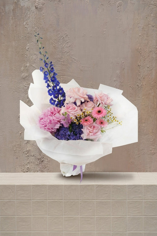Poetic Haze - blush pink roses, pink and purple hydrangeas, blue delphinium, and pink gerberas in a