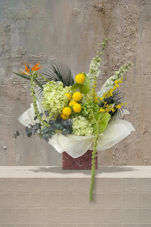 Sienna Grace - orange Bird of Paradise, yellow craspedia, lime hydrangeas, white snapdragons, and trailing amaranthus in a decorative gift box by Amicis