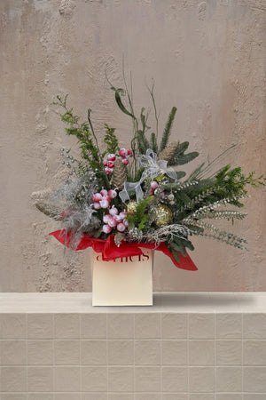 Sparkle Holidays 04 - festive green pine, frosted red berries, gold baubles, and silver foliage in a cream gift bag by Amicis