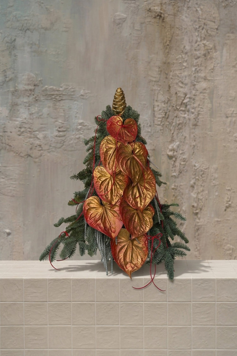 Sparkle Holidays 07 - gold and red anthurium with green fir branches and a golden pinecone in a festive tree arrangement by Amicis