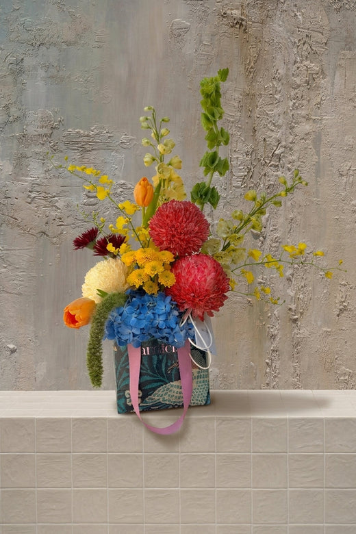 Tiny Treasure - mixed vibrant blooms including blue hydrangeas, red chrysanthemums, and orange